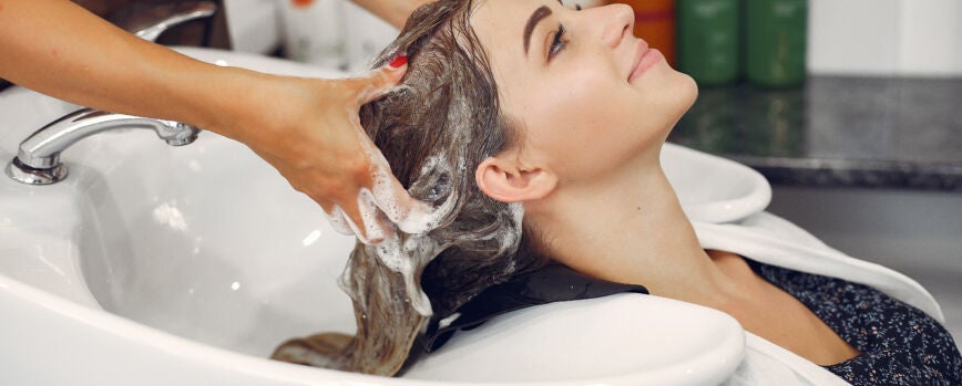 Hombre lavando el cabello de un cliente
