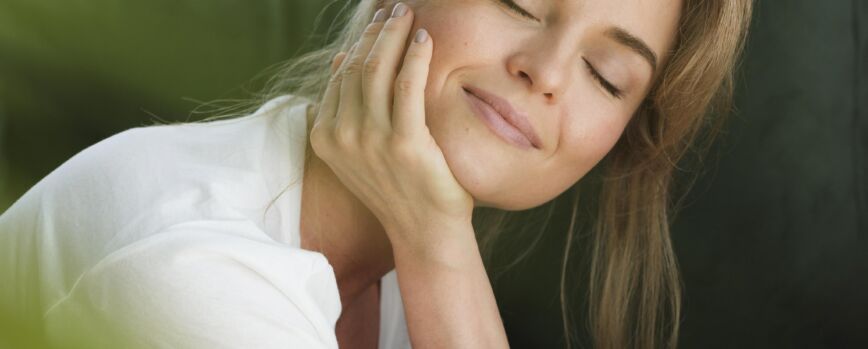 Mujer soñando despierta y planta borrosa