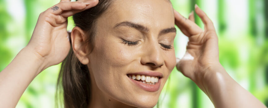Radiant woman with glossy skin and soft features posing in the studio advertising natural beauty and