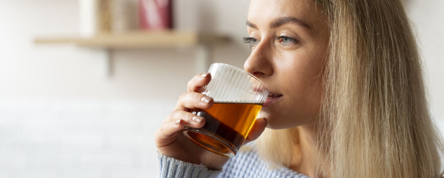Vista lateral mujer bebiendo kombucha